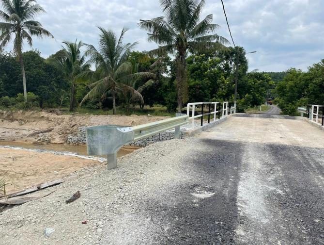 Completed concrete roadside drain alongside a finished road